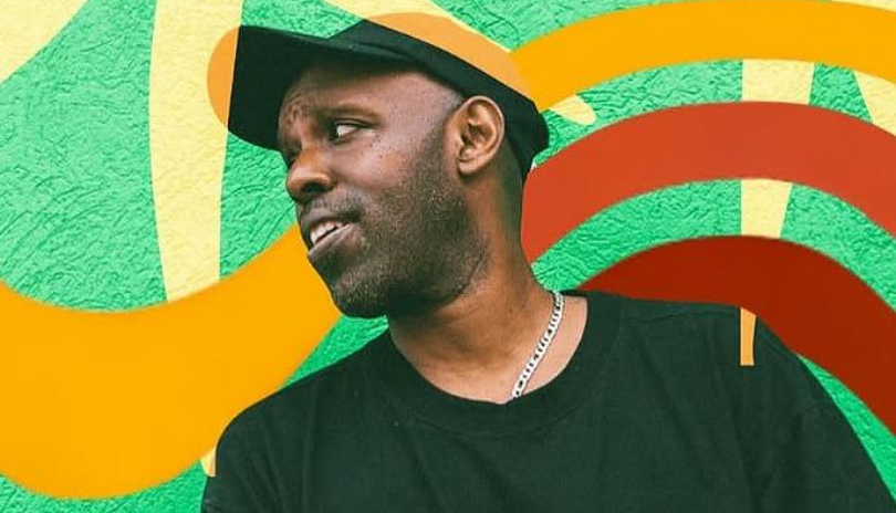 Headliner Shad stands in front of a colourful wall.